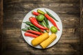 Red and green chili pepper, corn on plate on wooden background Royalty Free Stock Photo