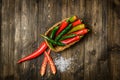 Red and green chili pepper on plate on wooden background Royalty Free Stock Photo