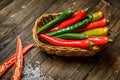 Red and green chili pepper on plate on wooden background Royalty Free Stock Photo