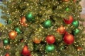 Red and green Christmas balls on a spruce branch close-up, festive New Year card background Royalty Free Stock Photo