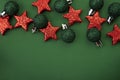 Red and green Christmas tree toys on a green background, copy space Royalty Free Stock Photo