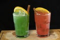 Red and Green Cocktails with red and green juices, alcohol and lime wedge