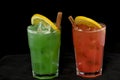 Red and Green Cocktails with red and green juices, alcohol and lime wedge