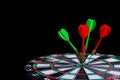 Red and green dart arrow hitting target center is Dart board Isolated on black background Royalty Free Stock Photo