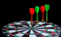 Red and green dart arrow hitting target center is Dart board Isolated on black background Royalty Free Stock Photo