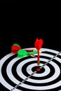 Red and green dart arrow hitting target center is Dart board Isolated on black background Royalty Free Stock Photo