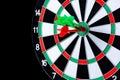 Red and green dart arrow hitting target center is Dart board Isolated on black background Royalty Free Stock Photo