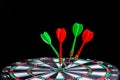 Red and green dart arrow hitting target center is Dart board Isolated on black background Royalty Free Stock Photo