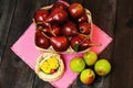 Red and green fresh pears in a wooden basket on a dark wooden table in the background of the garden. Easter basket with ciphers in