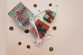 Red and green gift boxes lie in an eco-friendly white string bag on a beige background