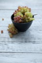 Red green grapes in a black bowl on a gray wooden table Royalty Free Stock Photo