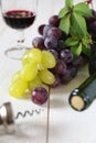 Red and green grapes, bottle, corkscrew and glass of red wine