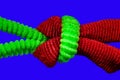 Red and green hair tie in a knot macro on a blue background Royalty Free Stock Photo