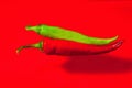 Red and green hot pepper on a red background Royalty Free Stock Photo