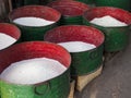 Red and green metal vats of rice in traditional food market