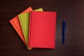 red green orange leather notebook with pencil on wooden background Royalty Free Stock Photo