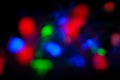 Red, green, pink, blue, blurry christmas and holiday lights in the dark. Multicolored, bright blurred bokeh background Royalty Free Stock Photo