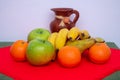 Red and green tablecloth with pears, bananas, oranges and fresh green apples Royalty Free Stock Photo