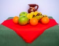 Red and green tablecloth with pears, bananas, oranges and fresh green apples Royalty Free Stock Photo