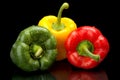 Red,green,yellow bell peppers isolated on black