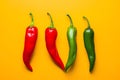 Red, green and yellow chili peppers isolated on yellow background. Hot spicy food ingredient Royalty Free Stock Photo