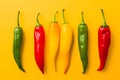 Red, green and yellow chili peppers isolated on yellow background. Hot spicy food ingredient Royalty Free Stock Photo