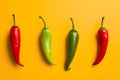 Red, green and yellow chili peppers isolated on yellow background. Hot spicy food ingredient Royalty Free Stock Photo