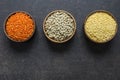 Red, green and yellow lentils in wooden bowl on grey rustic background Royalty Free Stock Photo