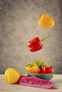 Red, green, yellow peppers with a bowl and napkin Royalty Free Stock Photo