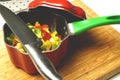 red green and yellow peppers in a pot on wooden background. cooking or gastronomy concept Royalty Free Stock Photo