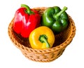 Red, green and yellow sweet bell peppers in a basket isolated on white background with clipping path Royalty Free Stock Photo