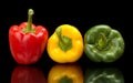 Red,green,yellow wet bell peppers on black with water drops Royalty Free Stock Photo