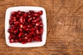 Red grenadine seeds on white plate