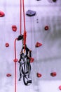 Red and grey rock climbing wall with carabiner hook and climbing