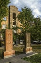 Two khachkars with carved patterns and crosses stand side by side in the Alley of stone crosses in Gyumri