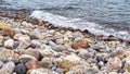 Red, grey, yellow and blue rocks on the shore of the lake Royalty Free Stock Photo