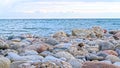 Red, grey, yellow and blue rocks on the shore of the lake Royalty Free Stock Photo