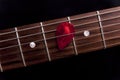 Red guitar pick on the fingerboard Royalty Free Stock Photo