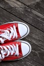 Red gym shoes on a wooden background. Sneakers on a wooden floor Royalty Free Stock Photo