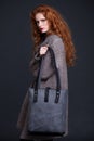 Red hair fashion model holding large leather bag Royalty Free Stock Photo