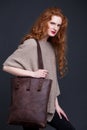 Red hair fashion model holding large leather bag Royalty Free Stock Photo