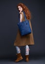 Red hair fashion model holding large leather bag