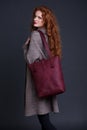 Red hair fashion model holding large leather bag Royalty Free Stock Photo