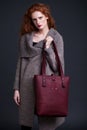 Red hair fashion model holding large leather bag Royalty Free Stock Photo