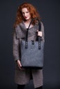 Red hair fashion model holding large leather bag Royalty Free Stock Photo