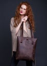 Red hair fashion model holding large leather bag Royalty Free Stock Photo