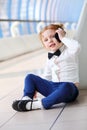 Red hair little cute girl talks by cell phone on Royalty Free Stock Photo