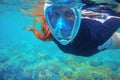 Red hair snorkeling girl full-face snorkeling mask in coral reef. Snorkel in coral reef of tropical sea. Royalty Free Stock Photo