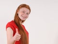 Red hair tennager girl in a red shirt showing a thumbs-up