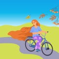 Red hair young woman rides a bicycle. Autumn journey on sunny landscape